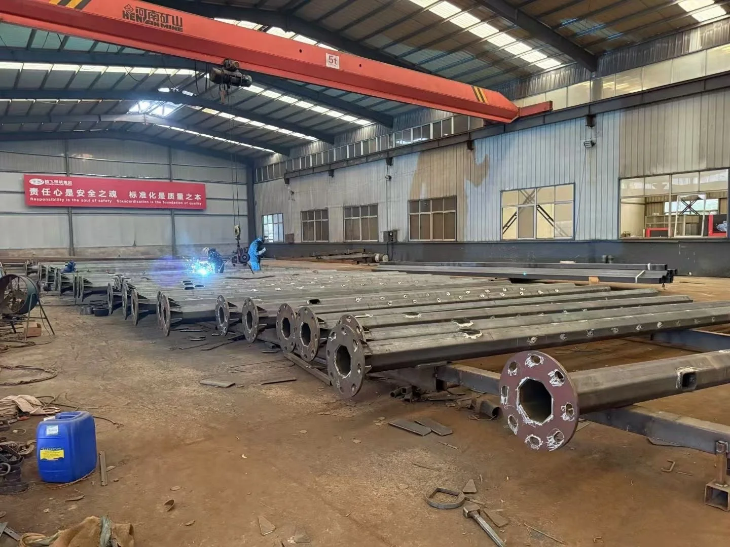 Steel pole sections in a fabrication workshop