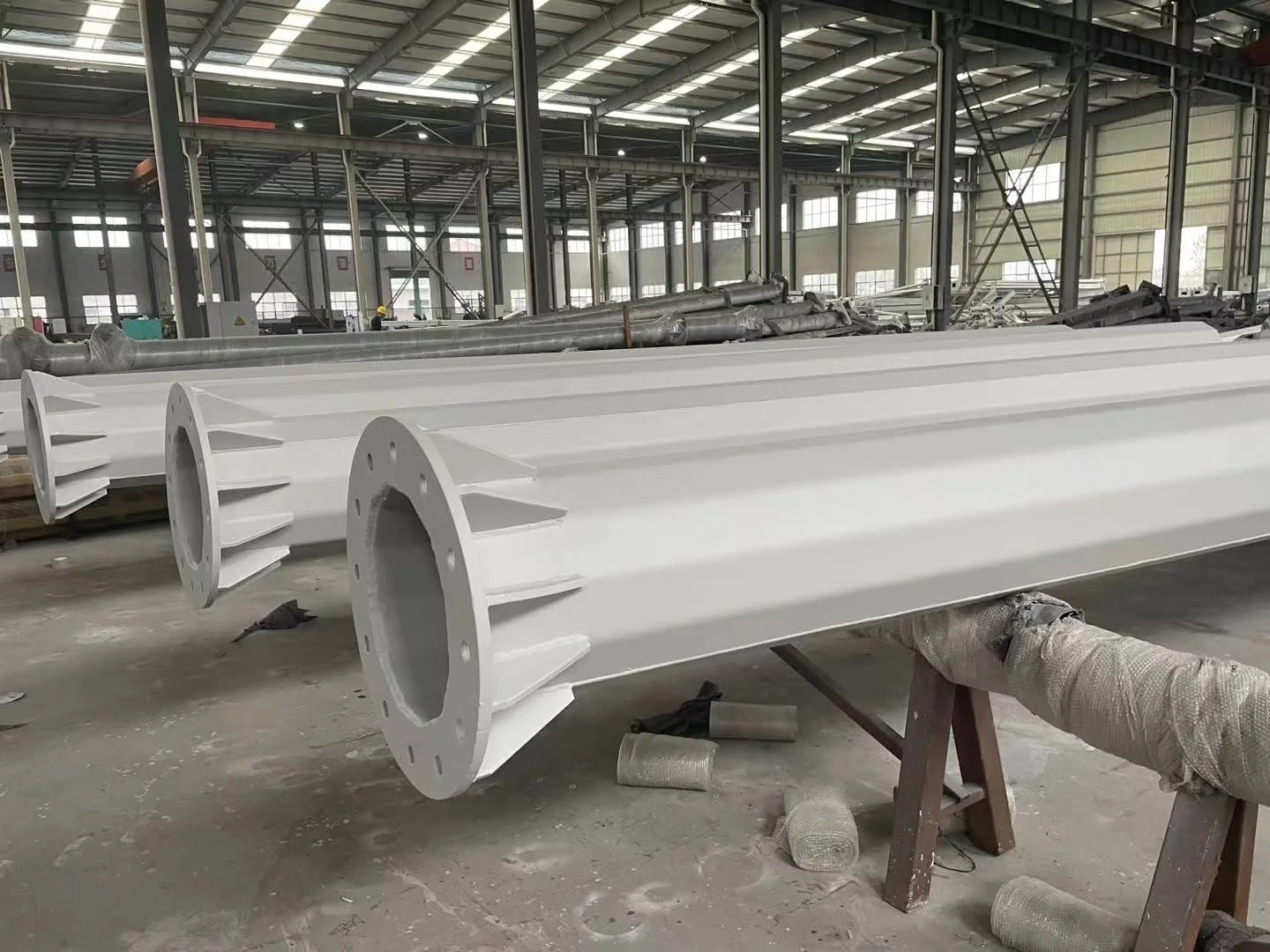 Coated steel pole sections with base flanges